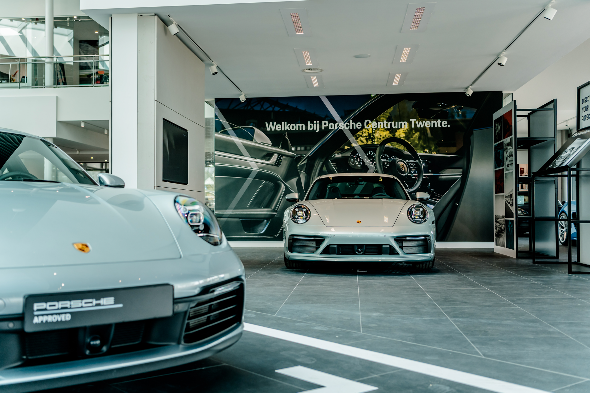 Showroom met twee Porsche sportauto’s bij Porsche Centrum Twente.