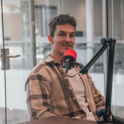 Jordi zit voor een podcastmicrofoon in de PCT studio.